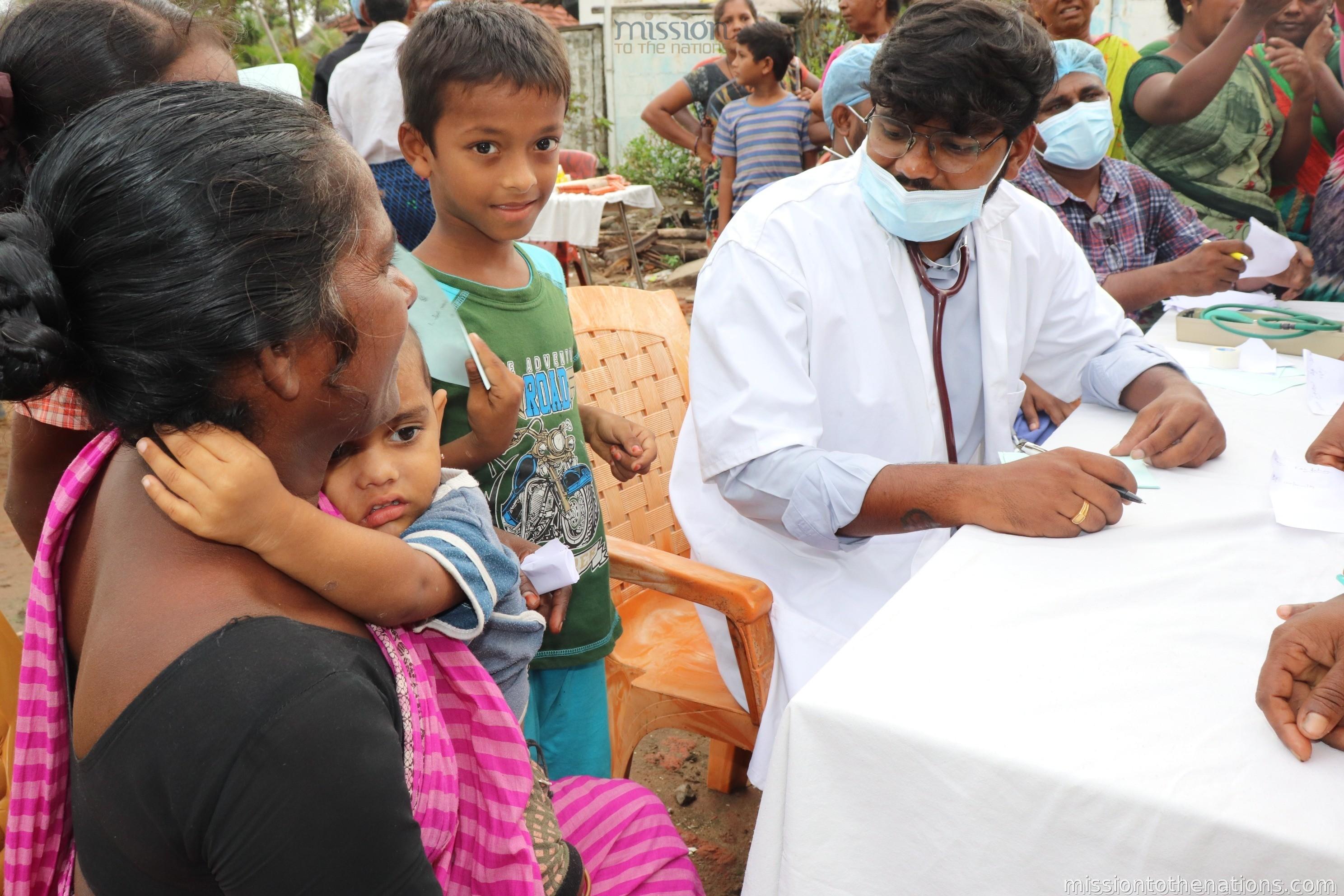 Doctor with mother and infant at camp