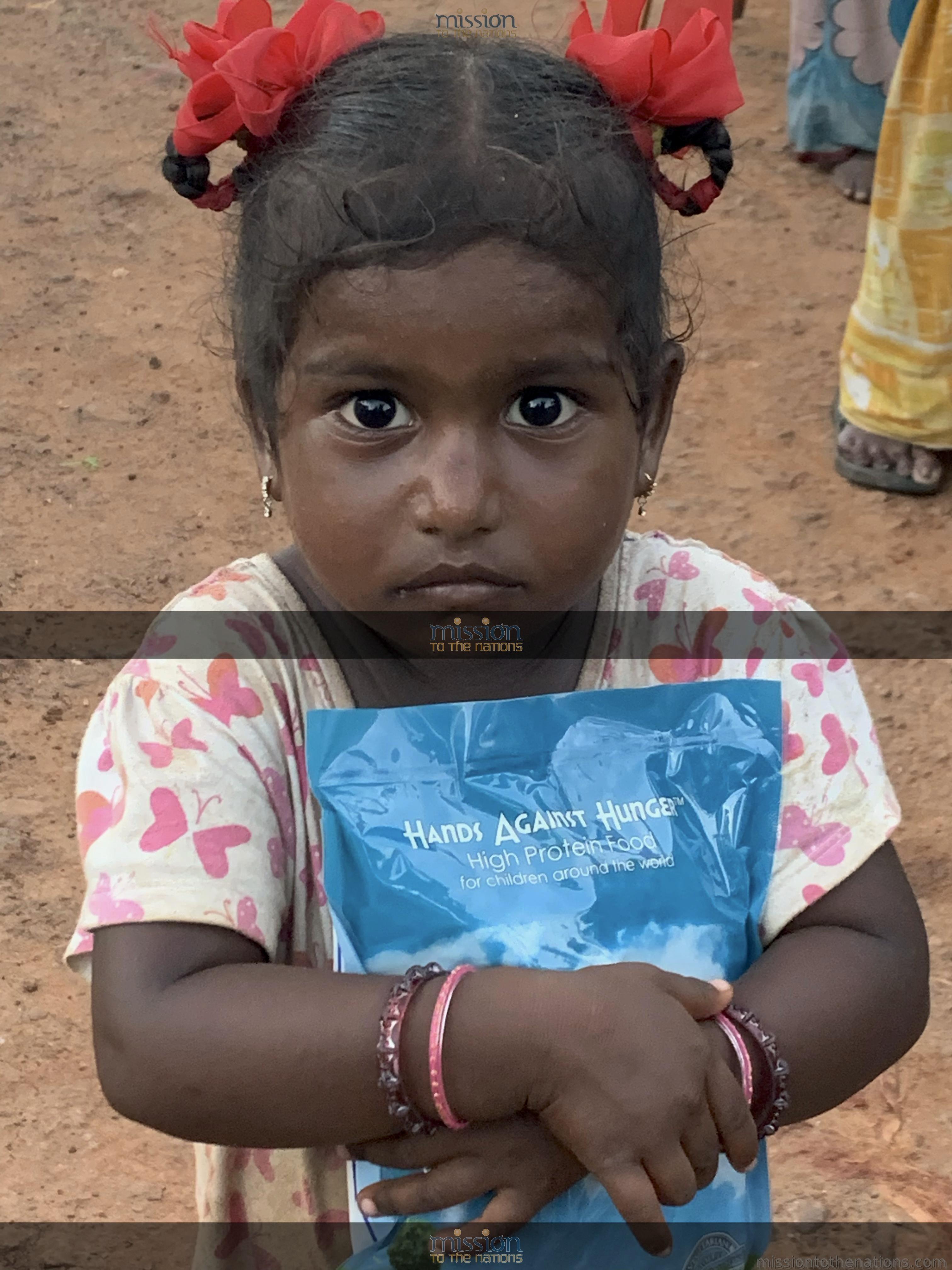 A girl holds her food packet