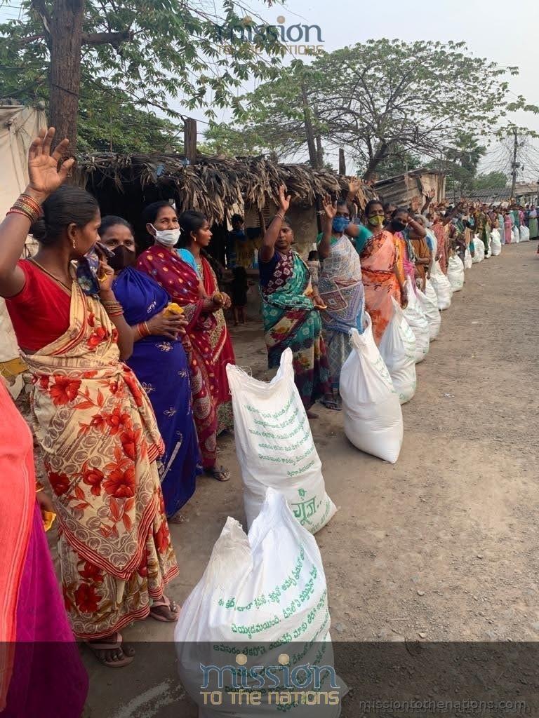 Food relief distribution — women receive rice bags