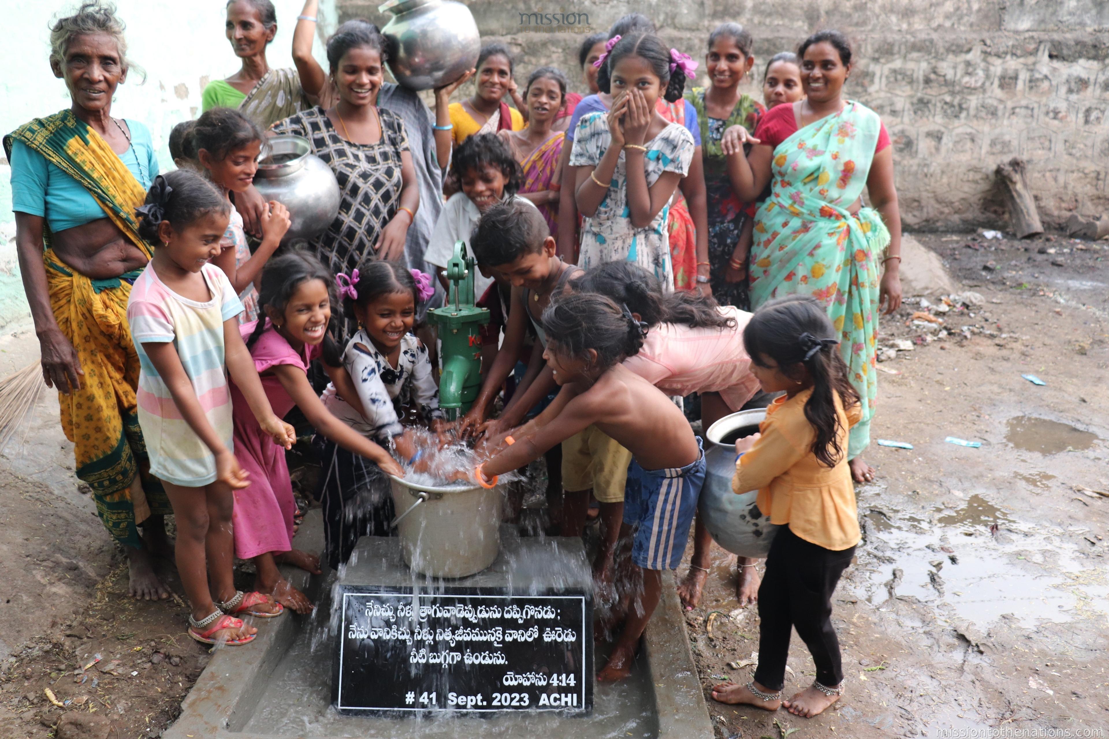 After — villagers at the new clean water hand pump