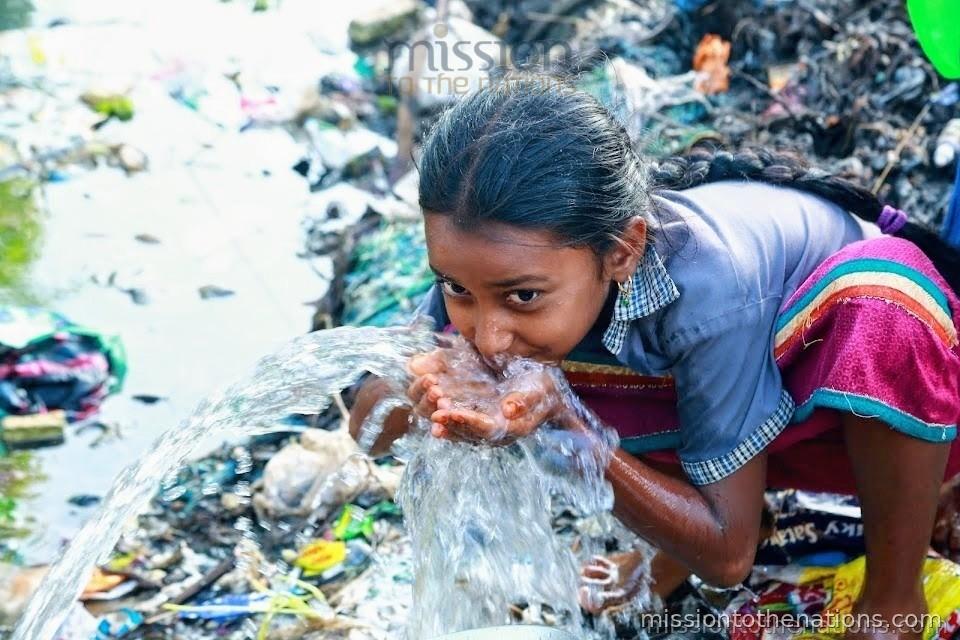 A girl drinking from a contaminated water source — what girls face before this programme
