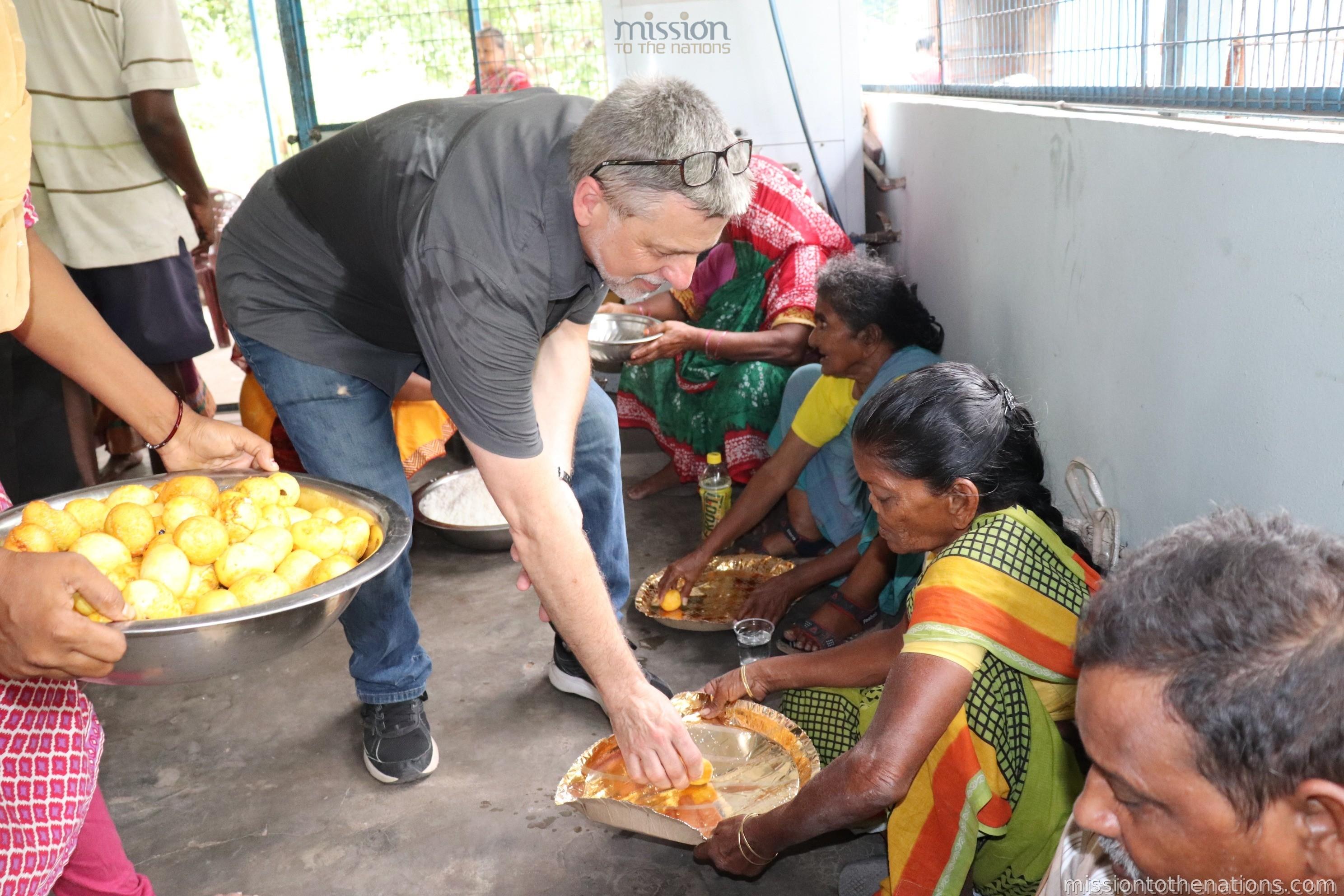 Volunteer serving food to leprosy patients