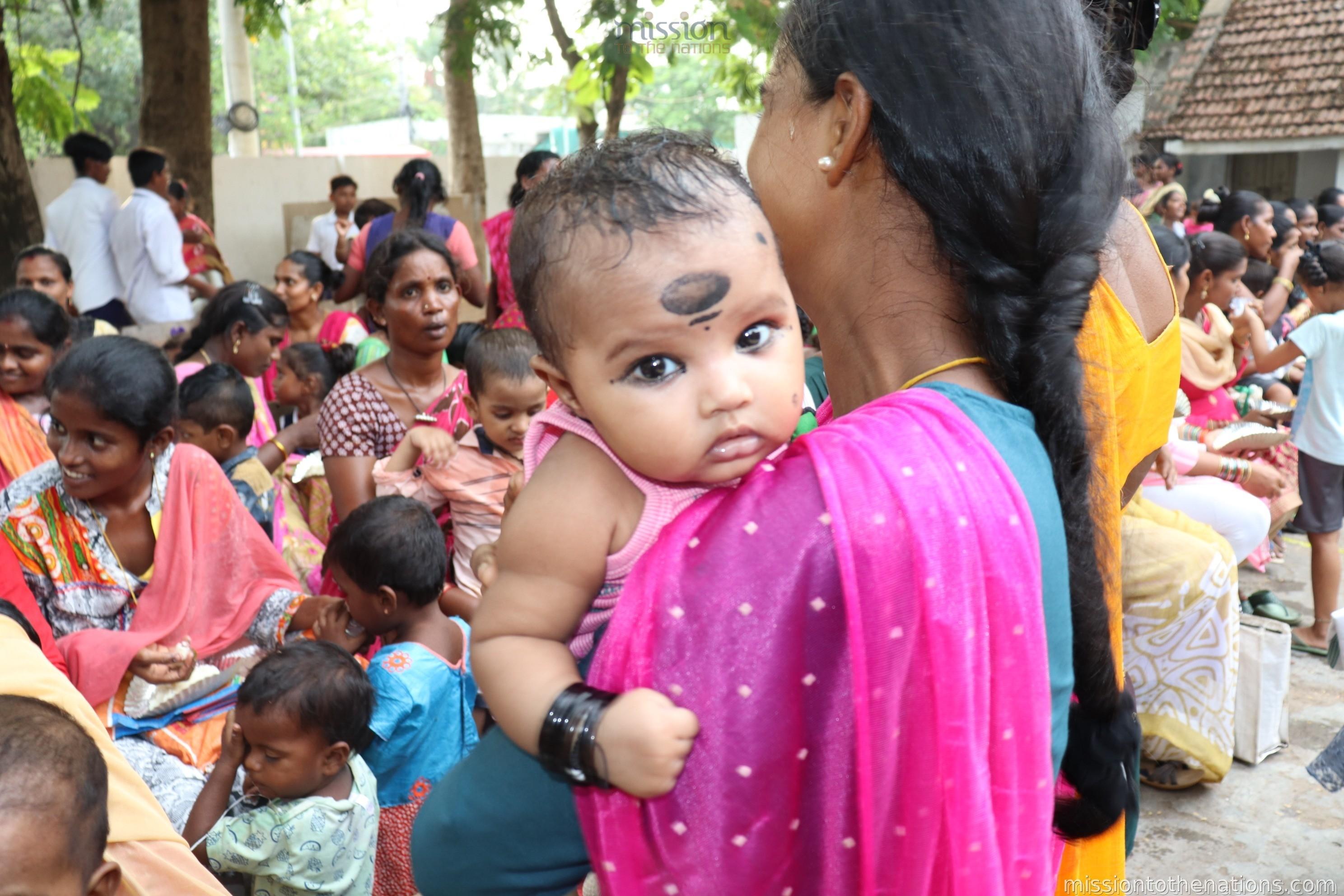 Mother carrying infant at MTN health camp