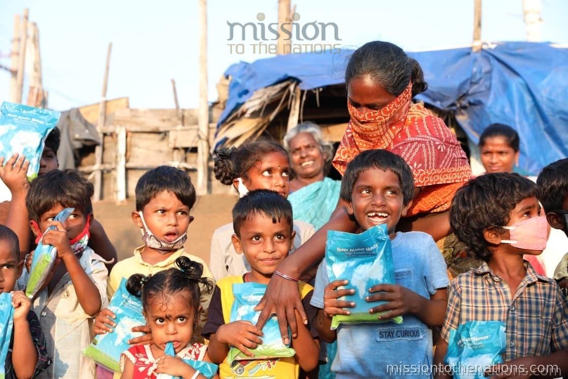 Children receiving food packets at an MTN street feeding distribution